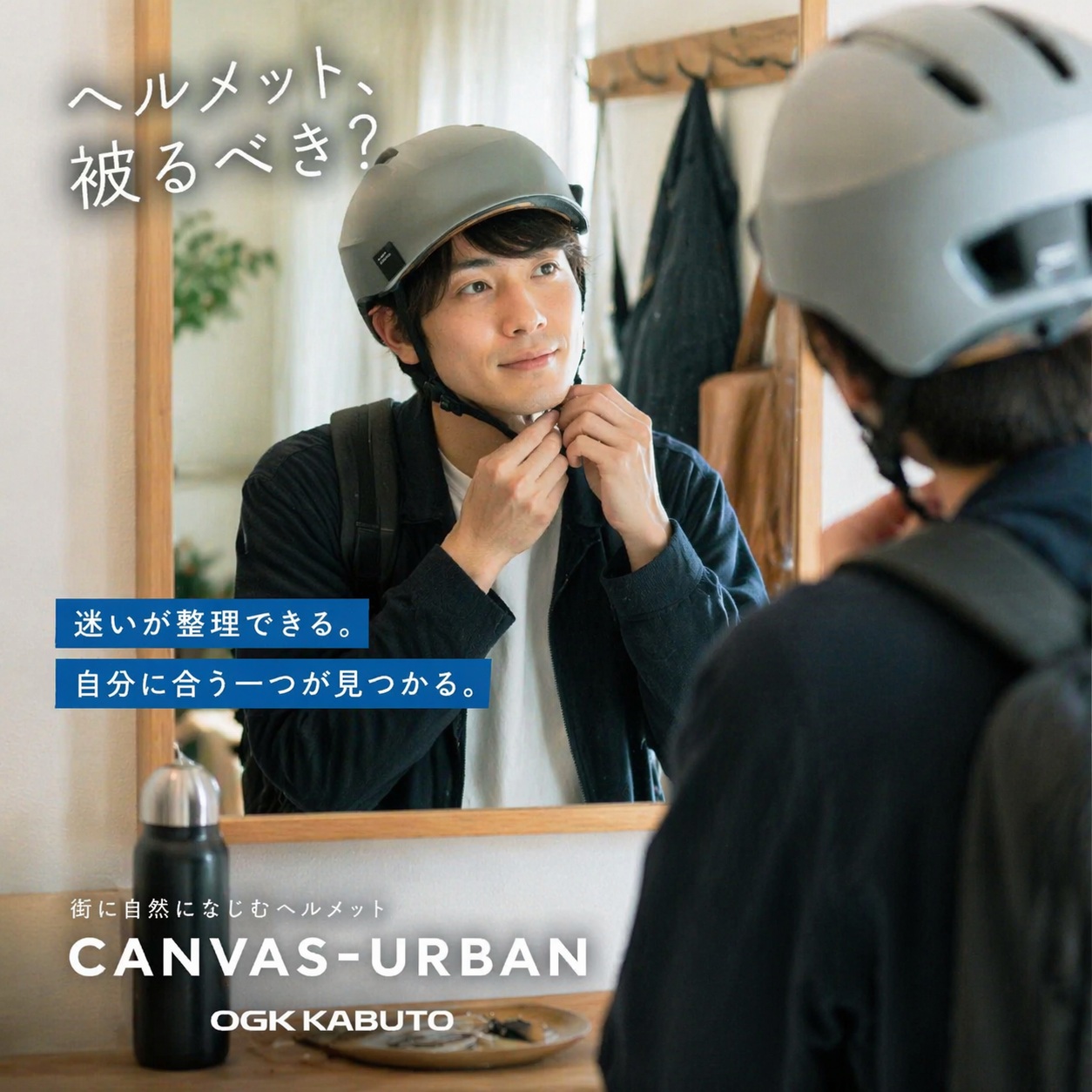 鏡の前でOGK CANVAS-URBANヘルメットを被りながら悩む男性｜自転車ヘルメットの必要性と選び方のイメージ