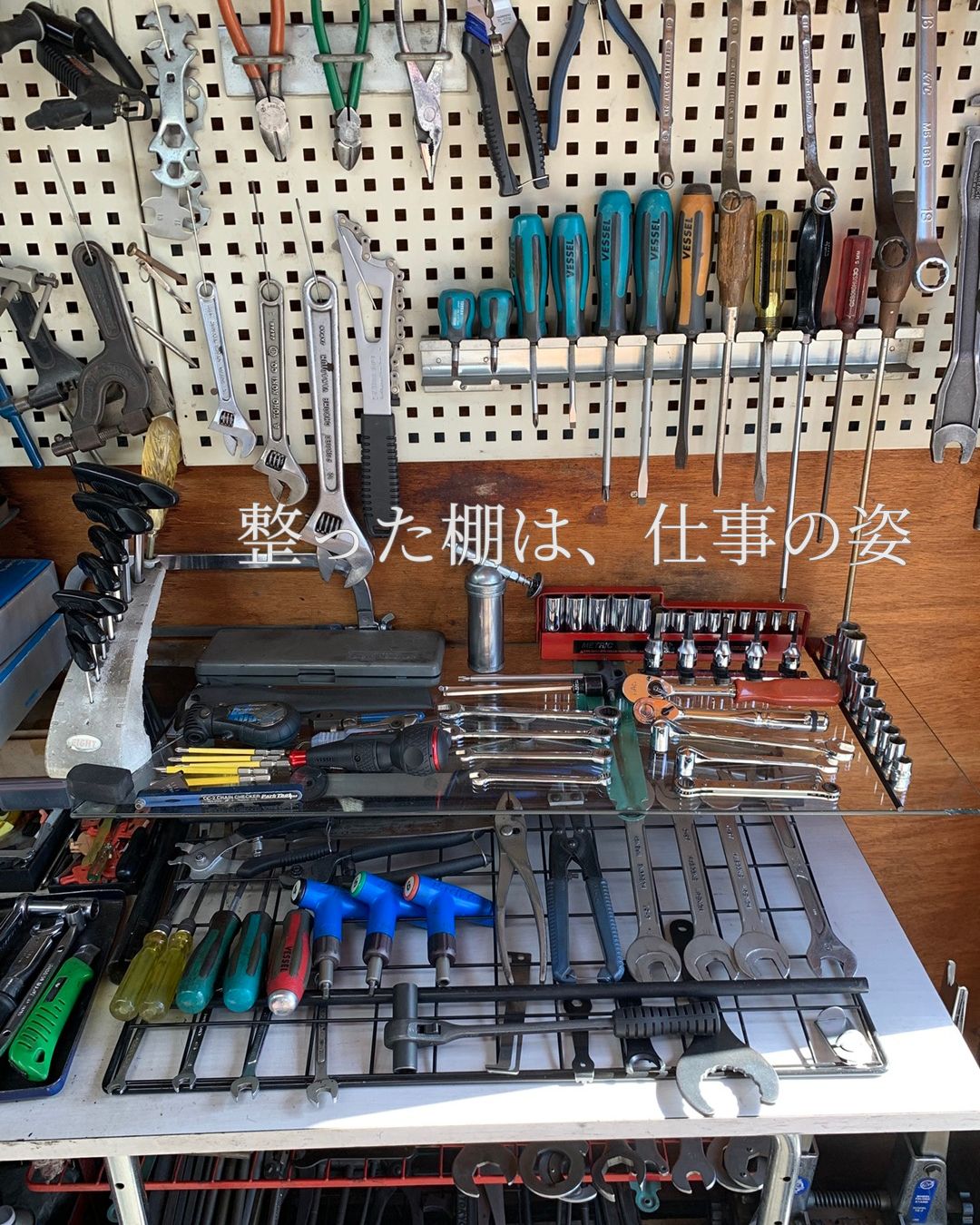 壁面に整然と並べられた自転車整備用の工具棚。 ドライバーやレンチ、専用工具が用途ごとに配置され、 日々の作業から生まれる秩序と誠実な仕事の積み重ねが感じられる一角。
